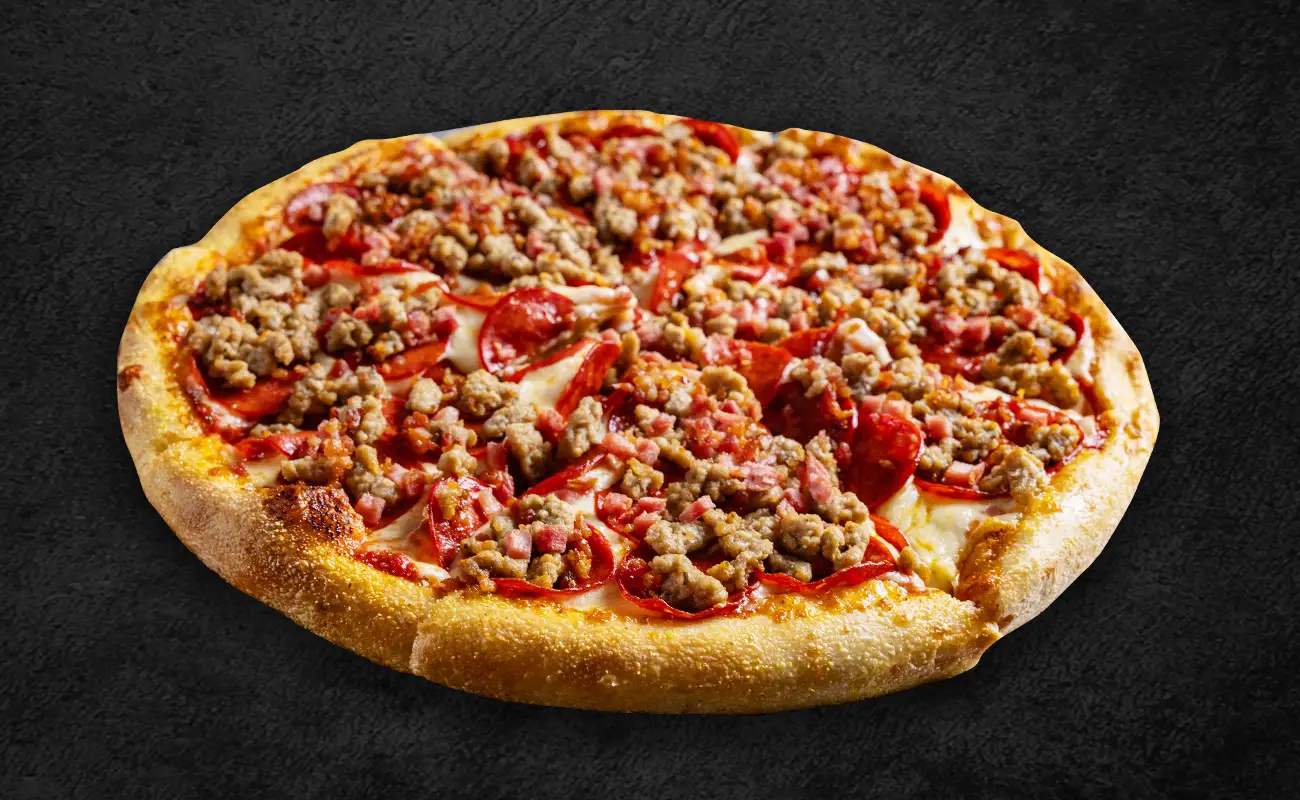 A hearty pizza topped with generous portions of pepperoni, crumbled sausage, diced ham, and melted cheese on a golden, thick crust.