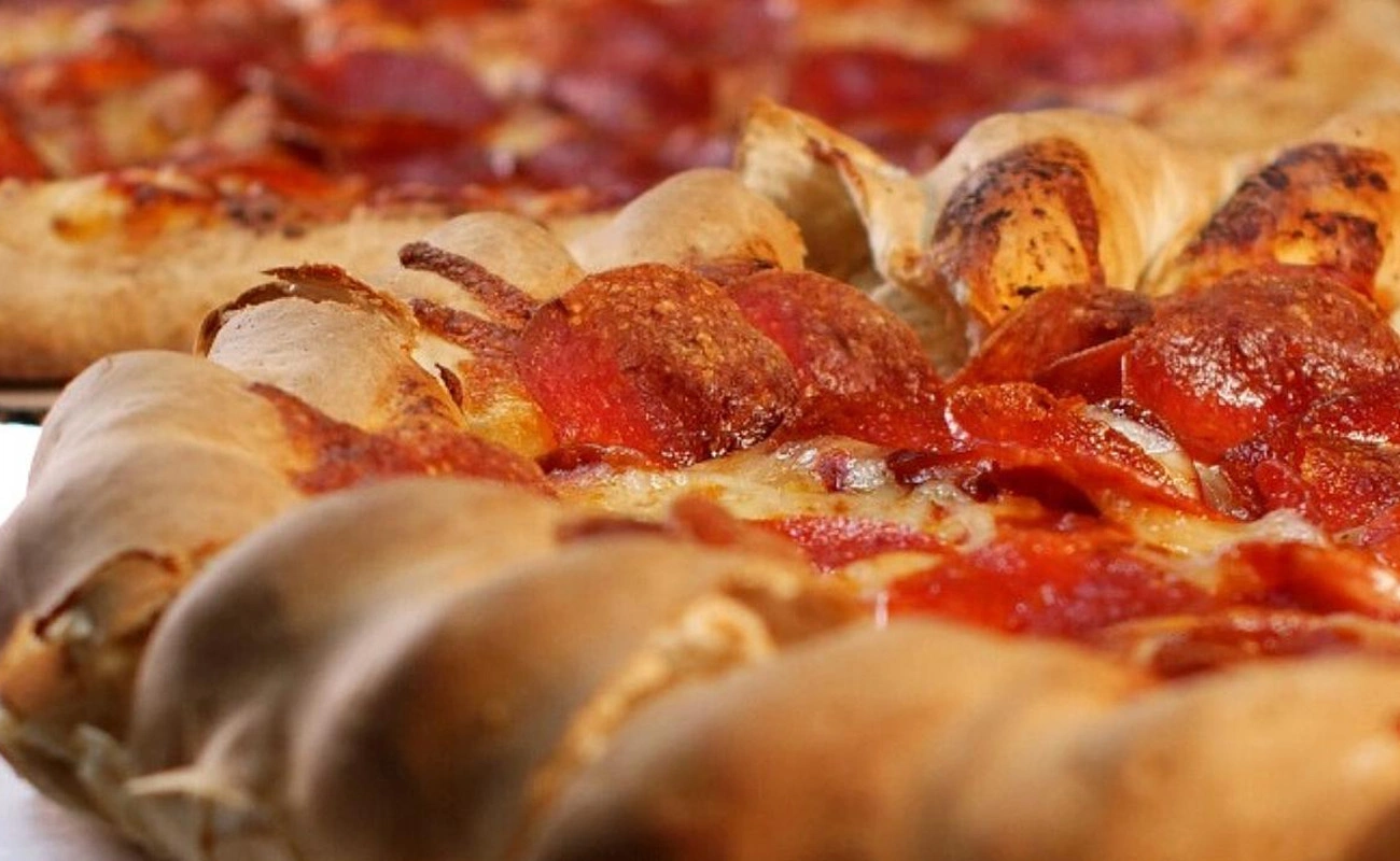 Colorado-style mountain pie pizza with thick honey-sweetened crust, loaded with cheese, toppings, and served in a deep pan.