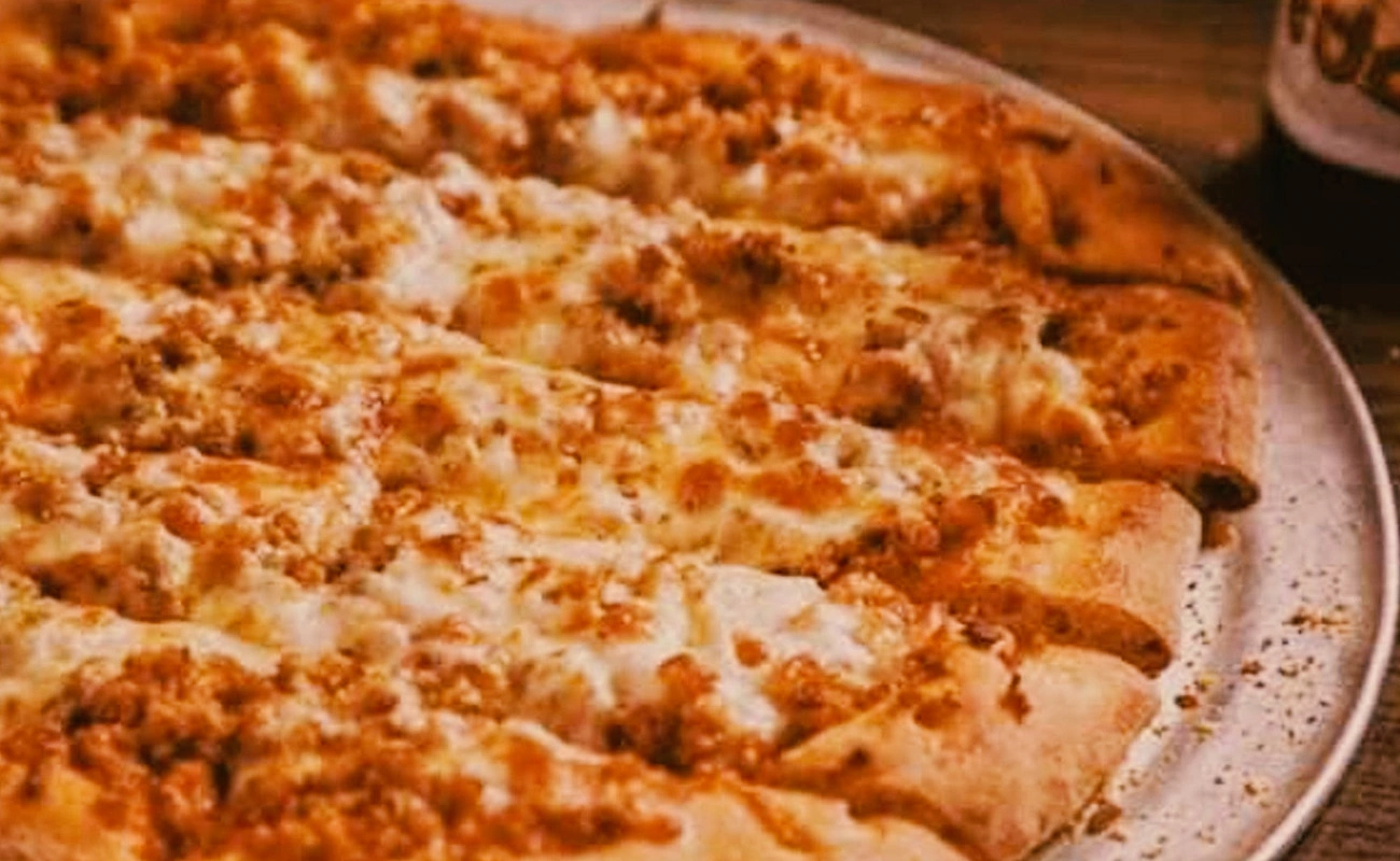 Quad Cities-style pizza with malt-flavored crust, spicy sausage topping, and cut into long strips.