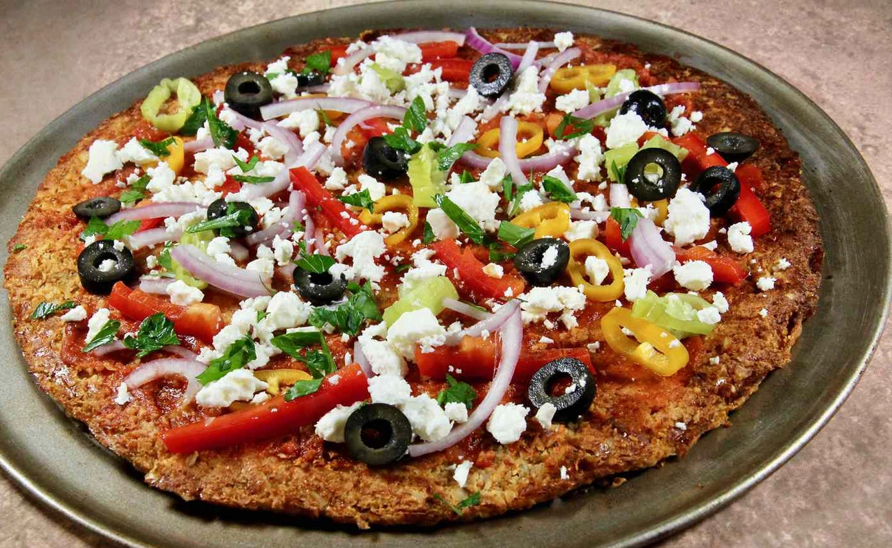 Cauliflower crust veggie supreme pizza topped with fresh vegetables, mushrooms, onions, and greens – healthy gluten-free pizza